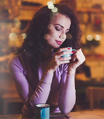 Beautiful woman enjoying aromatic coffee